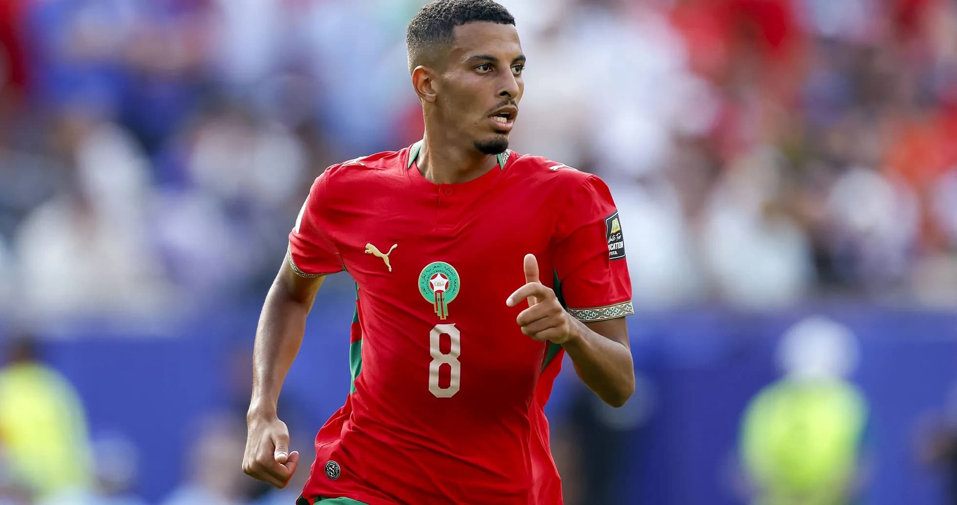 Jugador de Marruecos corriendo con balón durante partido Jugador de Marruecos corriendo con balón durante partido