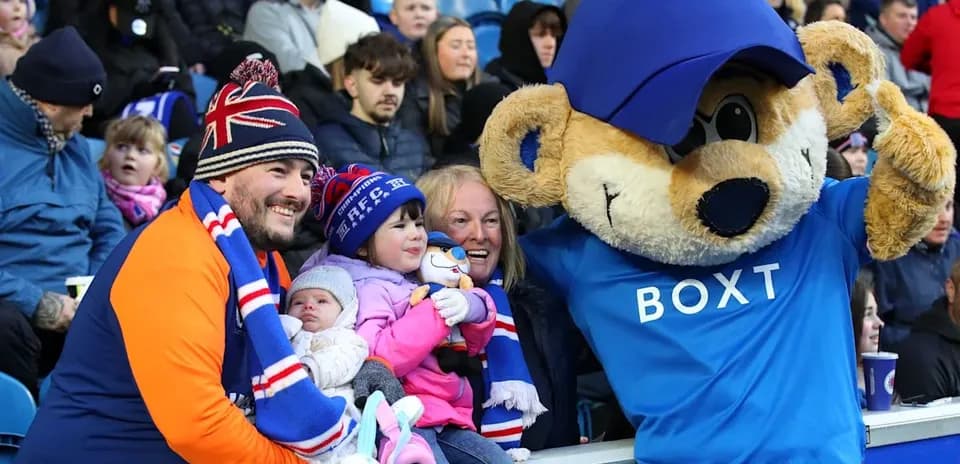Familia y mascota en el estadio durante el partido Familia y mascota en el estadio durante el partido