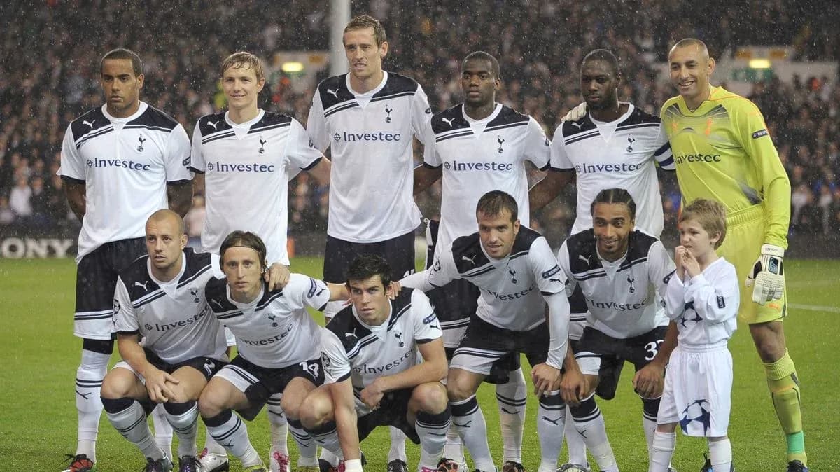 Equipo de Tottenham posando con un niño en el campo Equipo de Tottenham posando con un niño en el campo