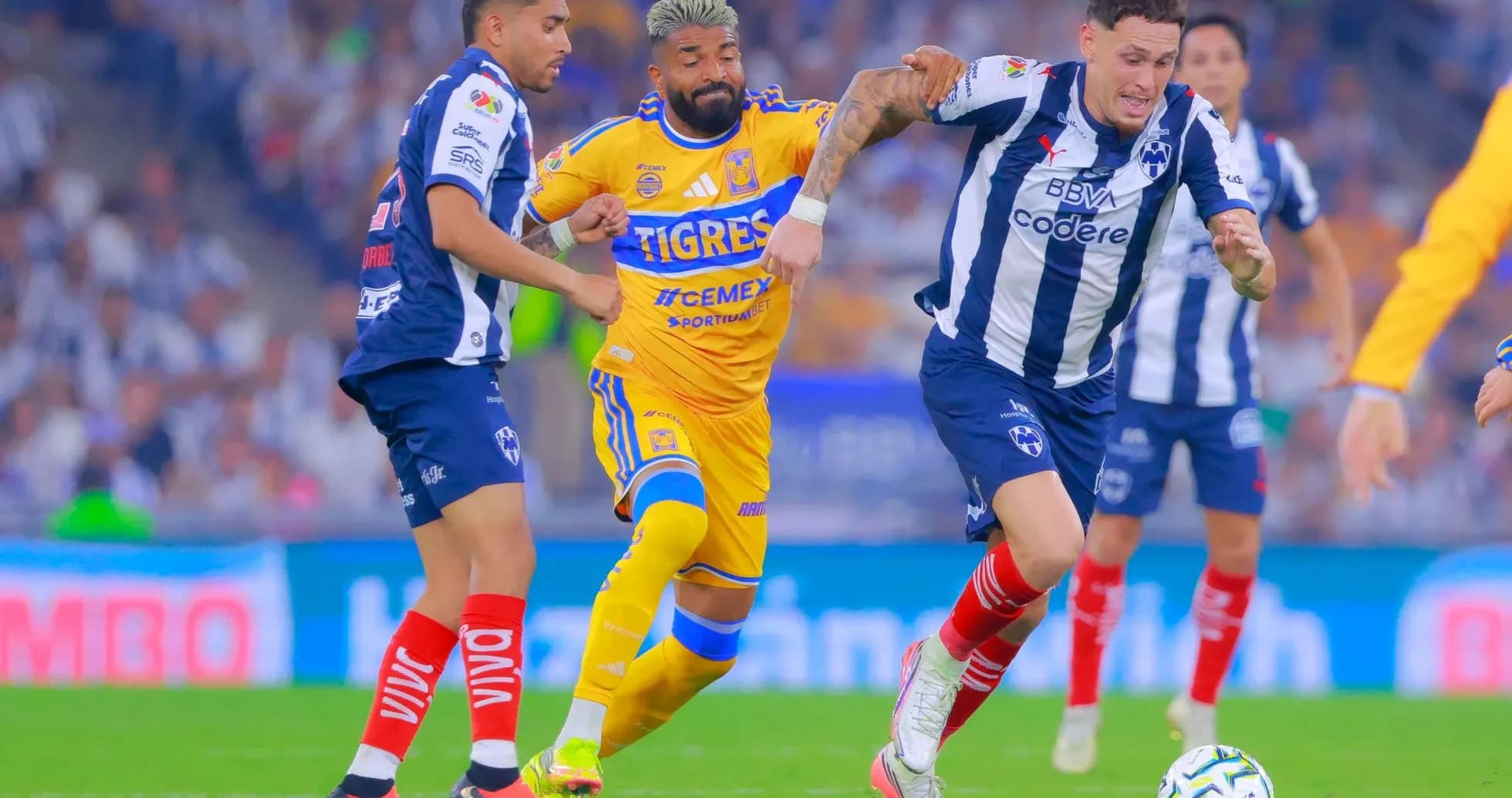 Jugadores de Monterrey y Tigres compitiendo por el balón Jugadores de Monterrey y Tigres compitiendo por el balón