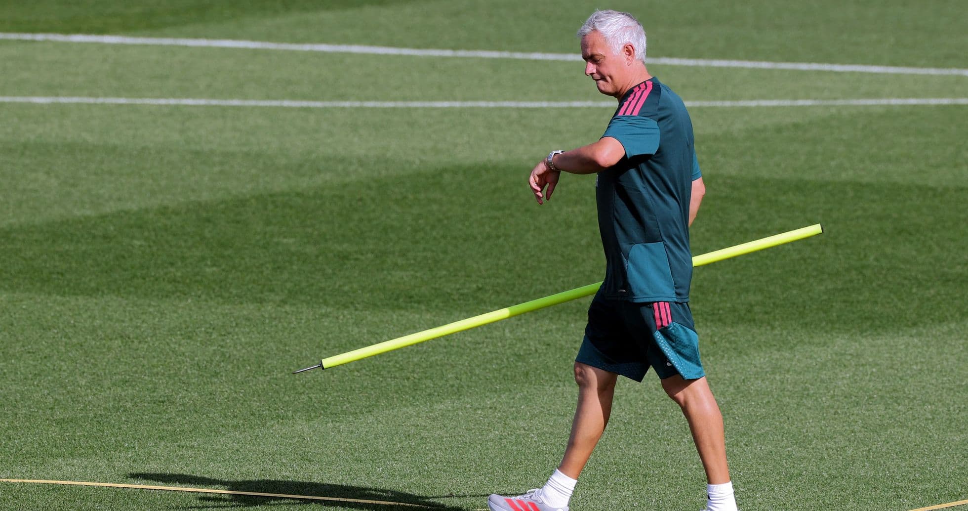 Entrenador caminando con un palo de entrenamiento Entrenador caminando con un palo de entrenamiento