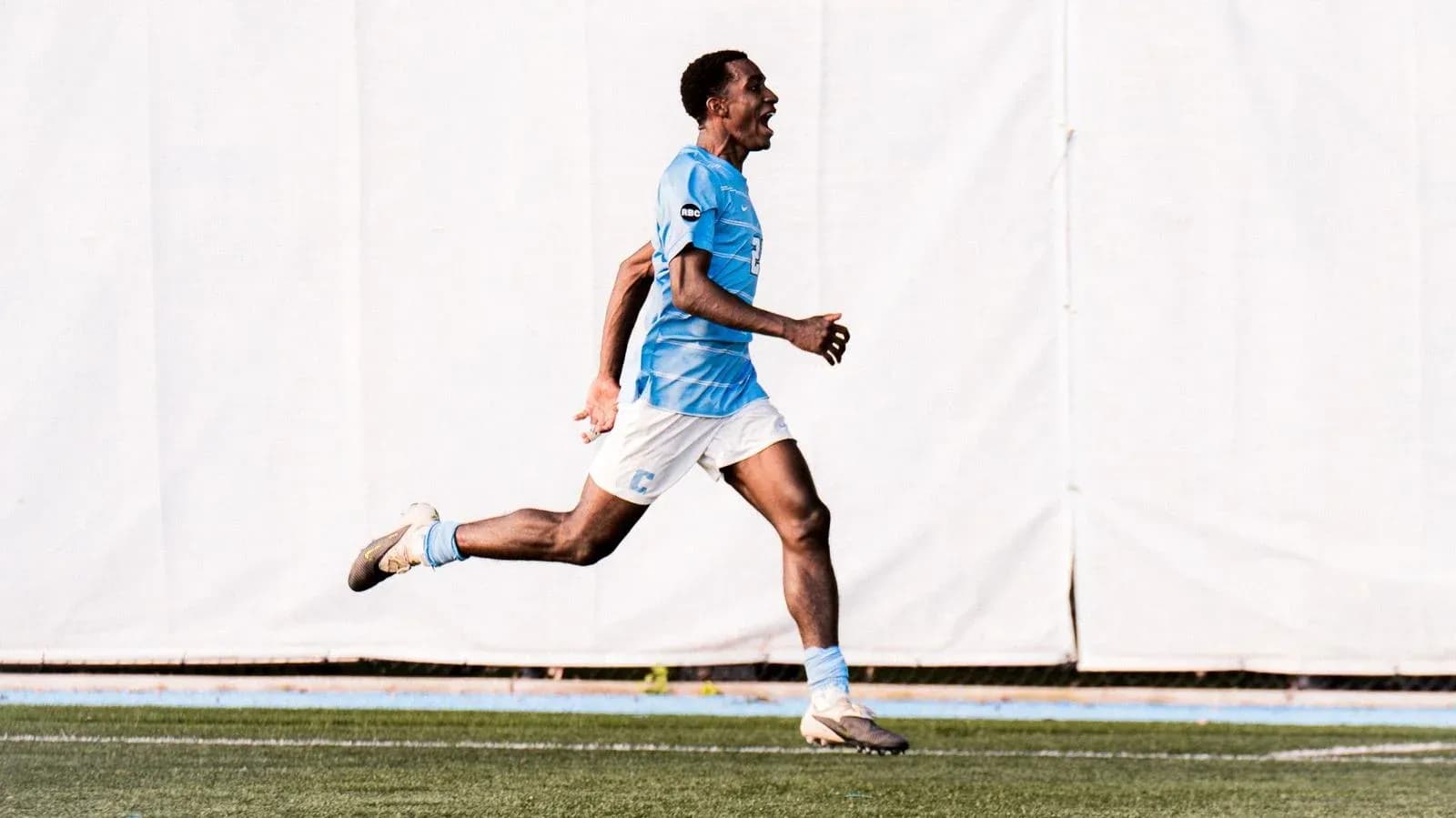 Jugador corriendo en el campo de fútbol Jugador corriendo en el campo de fútbol