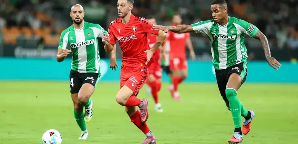Un jugador de Osasuna driblando a defensores de Betis Un jugador de Osasuna driblando a defensores de Betis