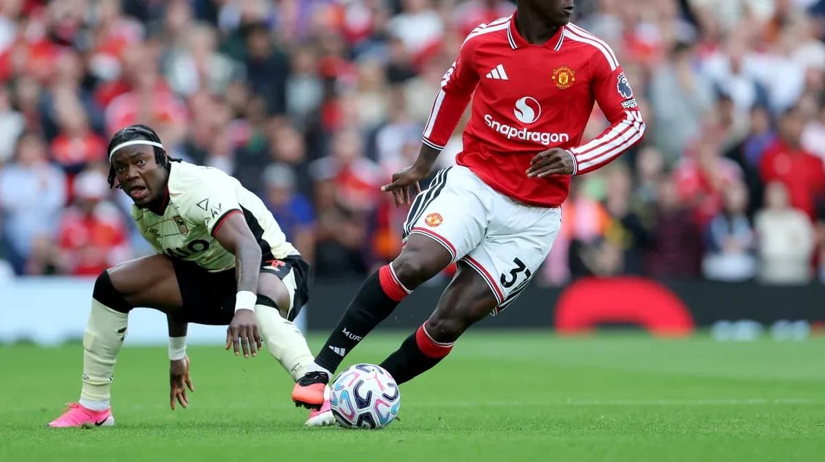 Jugador de Manchester United driblando a rival en el campo Jugador de Manchester United driblando a rival en el campo
