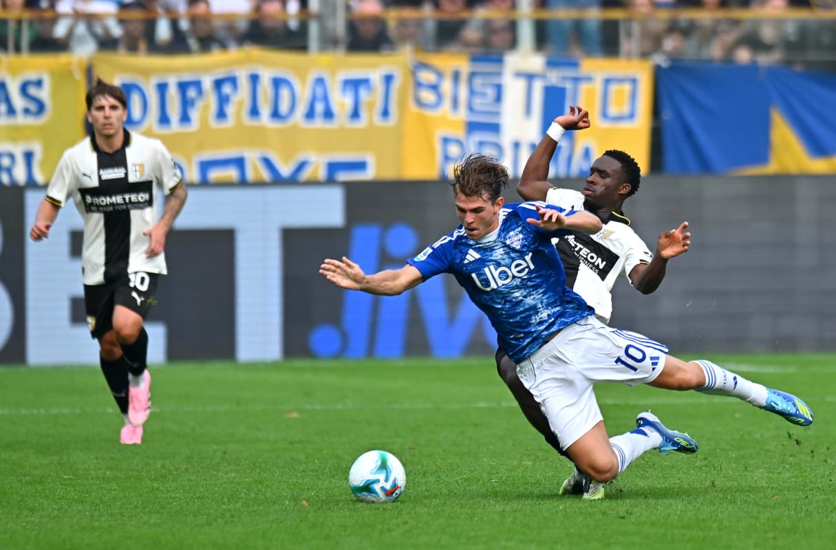 Jugador de Como cae mientras es tackleado por Parma Jugador de Como cae mientras es tackleado por Parma