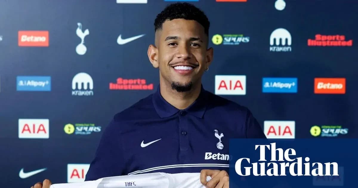 Jugador sonriente sosteniendo camiseta de Tottenham Jugador sonriente sosteniendo camiseta de Tottenham