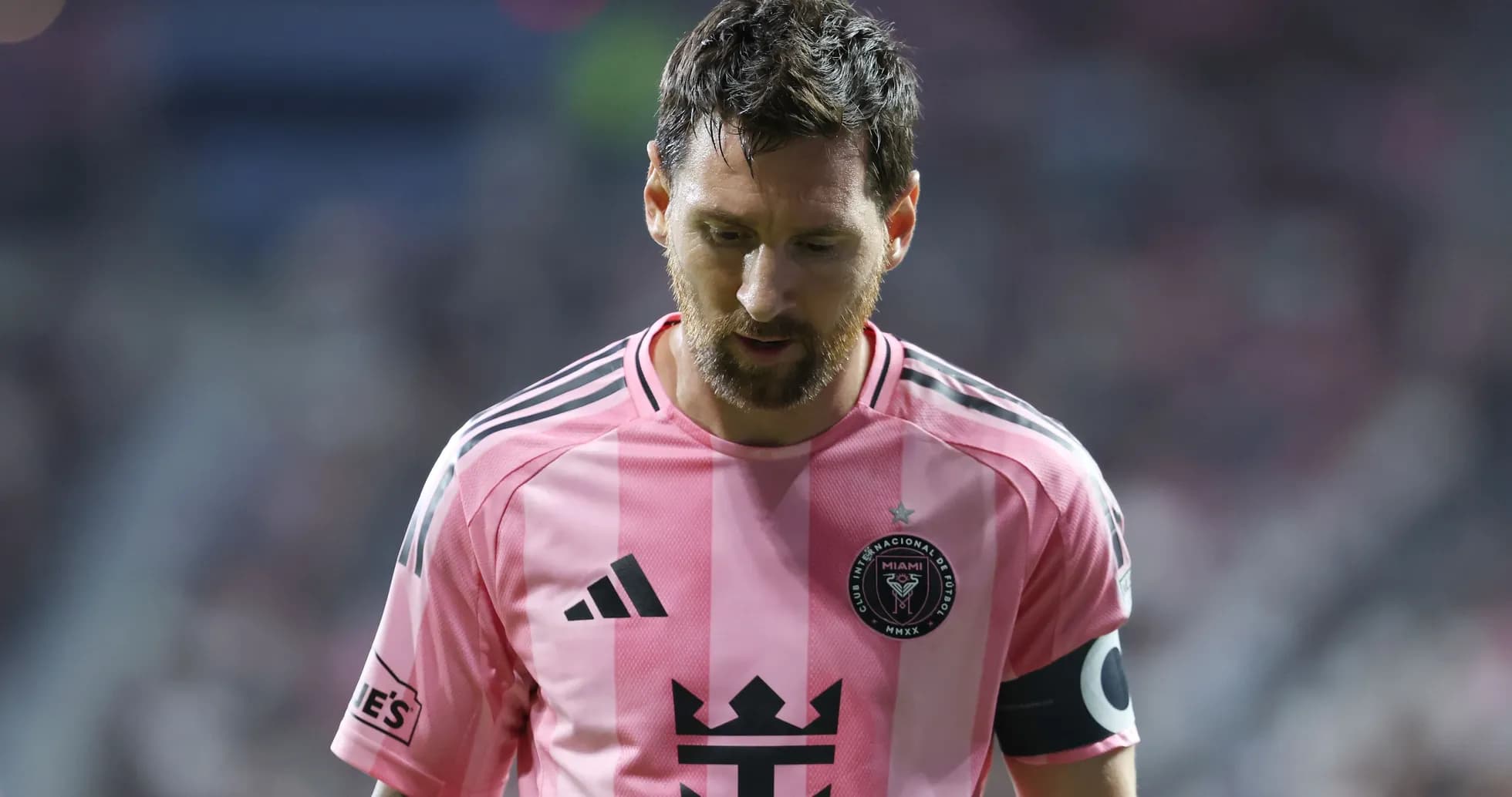 Jugador con camiseta rosa caminando en el campo Jugador con camiseta rosa caminando en el campo