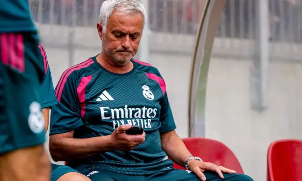 Entrenador sentado revisando su teléfono en el banquillo Entrenador sentado revisando su teléfono en el banquillo