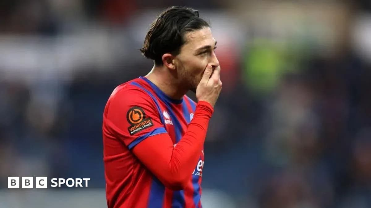 Jugador con camiseta roja sosteniendo su cara en el campo Jugador con camiseta roja sosteniendo su cara en el campo