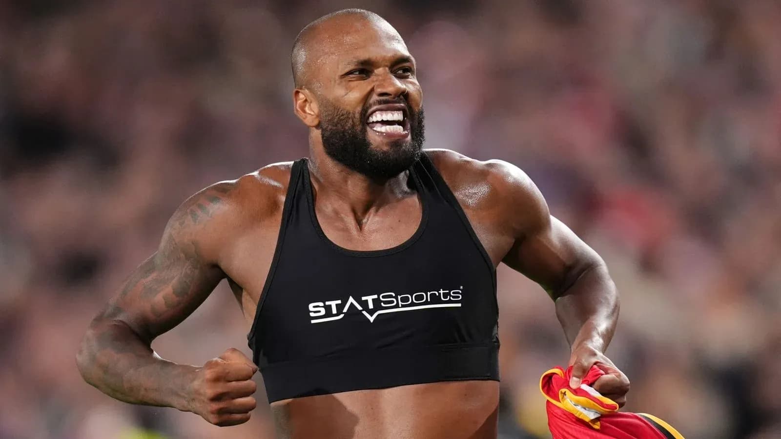 Atleta corriendo con camiseta de entrenamiento y sonriendo Atleta corriendo con camiseta de entrenamiento y sonriendo