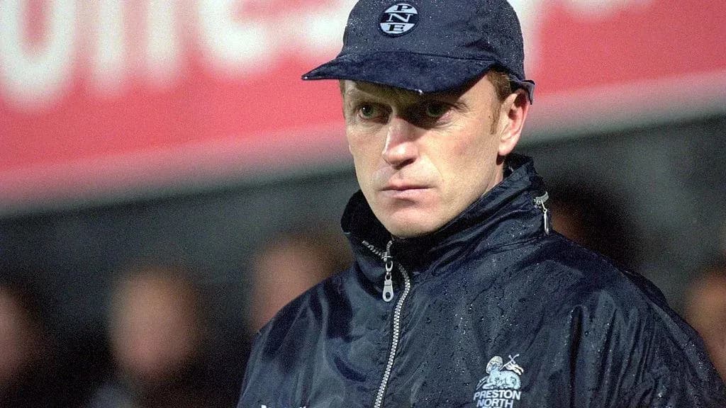 Entrenador de Preston North con abrigo y gorra Entrenador de Preston North con abrigo y gorra