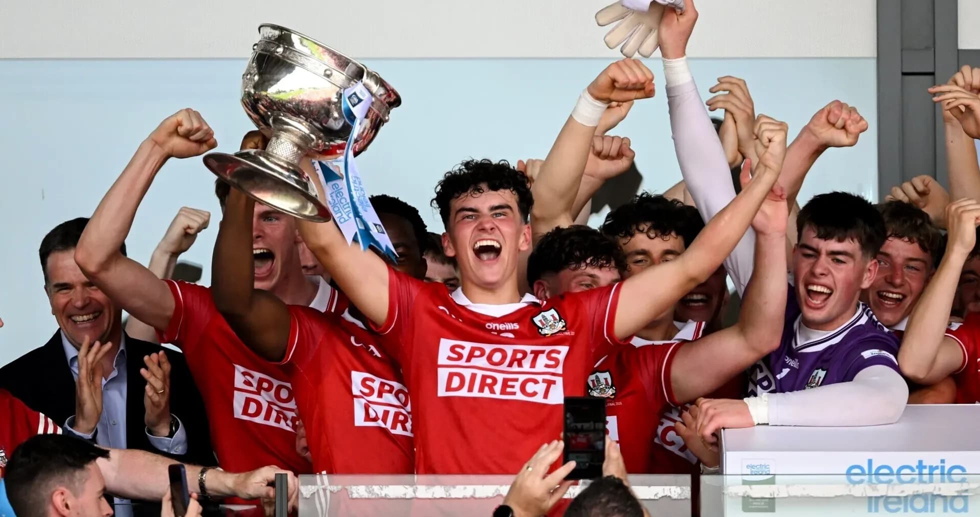 Jugadores levantando el trofeo de campeonato con entusiasmo Jugadores levantando el trofeo de campeonato con entusiasmo