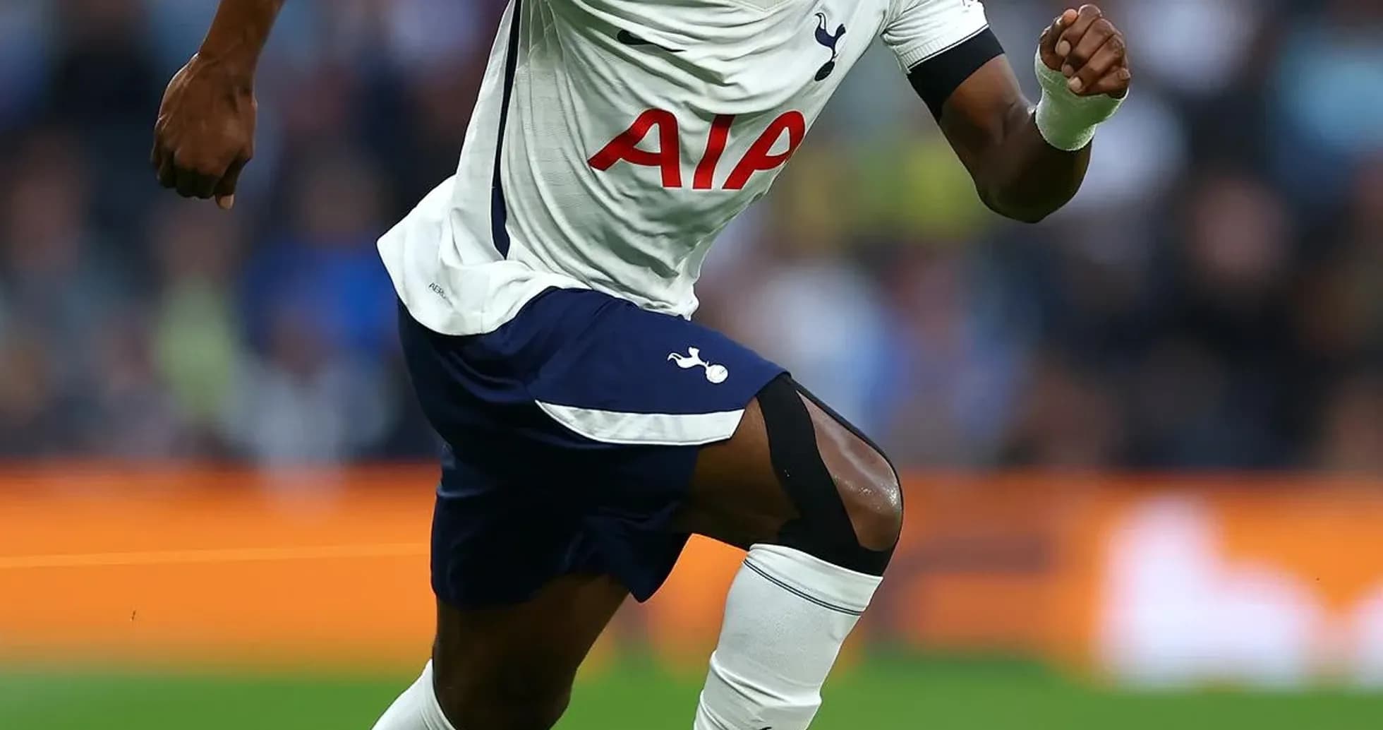 Jugador de Tottenham corriendo tras el balón en el campo Jugador de Tottenham corriendo tras el balón en el campo