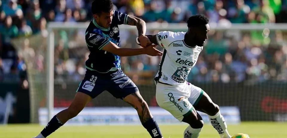 Jugador de León driblando a defensor de Puebla Jugador de León driblando a defensor de Puebla