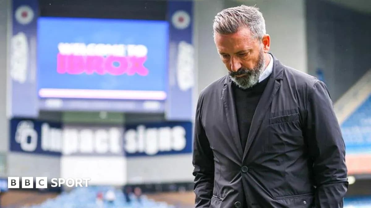 Entrenador caminando en Ibrox con mirada pensativa Entrenador caminando en Ibrox con mirada pensativa