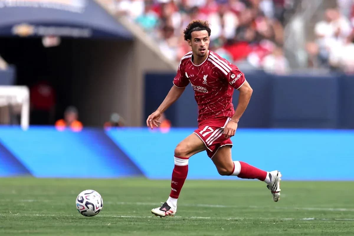 Jugador de Liverpool corriendo con el balón en campo Jugador de Liverpool corriendo con el balón en campo