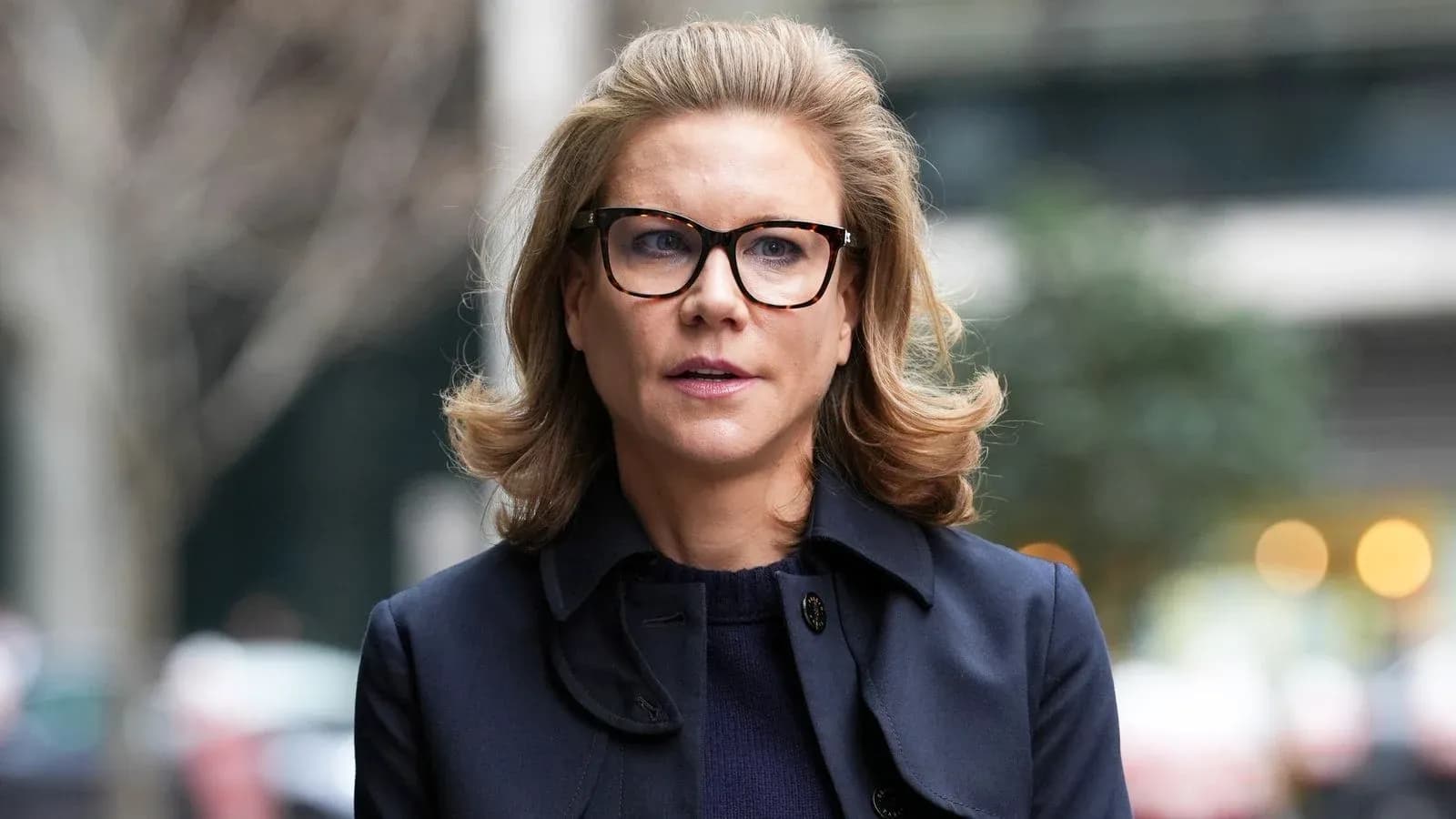 Mujer con gafas y abrigo oscuro en la calle Mujer con gafas y abrigo oscuro en la calle