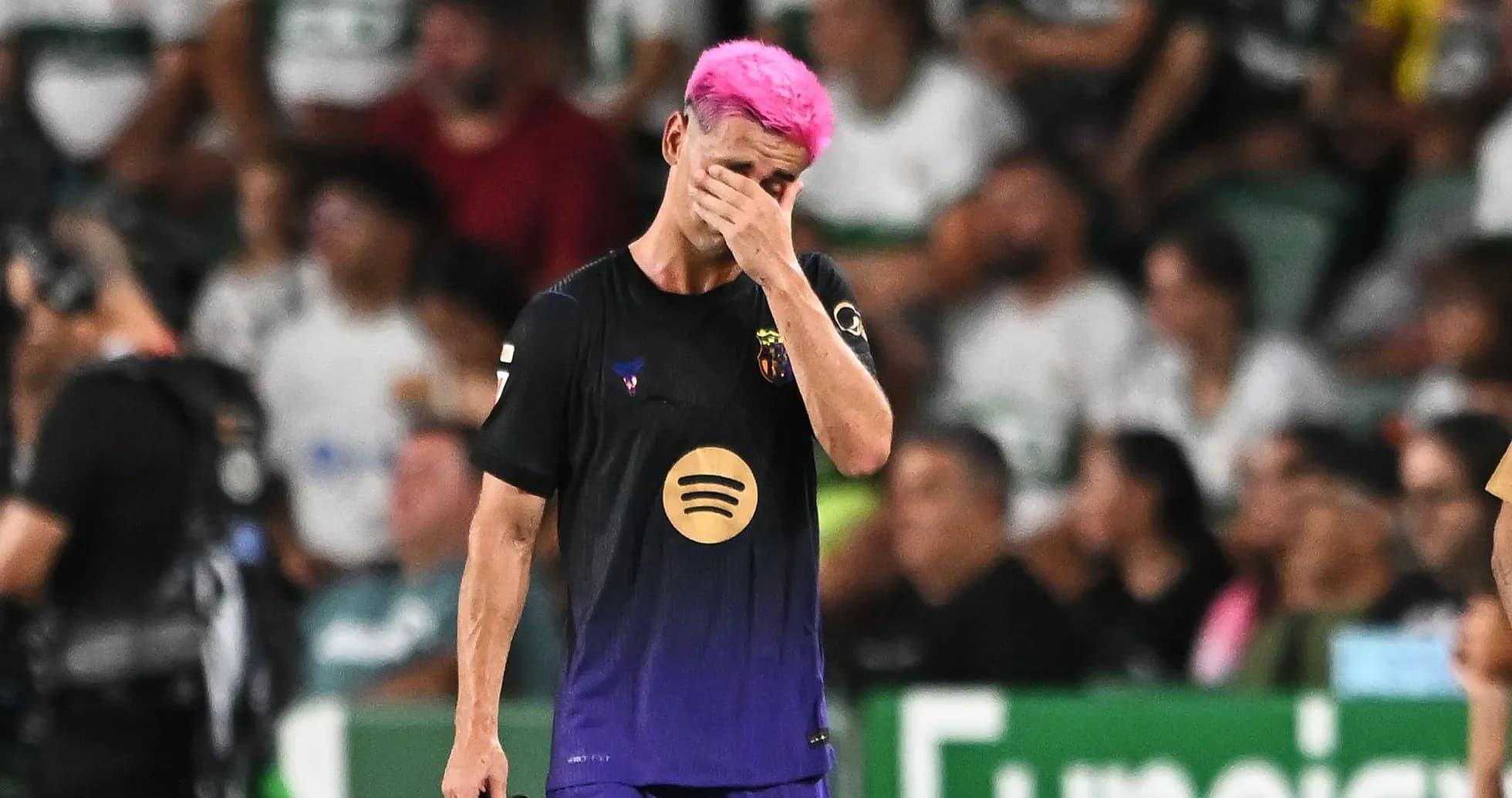 Jugador con cabello rosa se cubre la cara en el campo Jugador con cabello rosa se cubre la cara en el campo