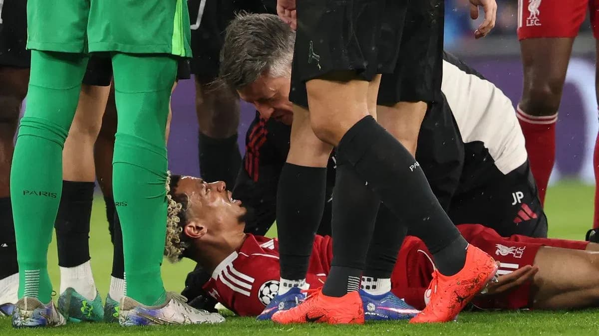 Jugador tendido en el suelo rodeado de compañeros Jugador tendido en el suelo rodeado de compañeros