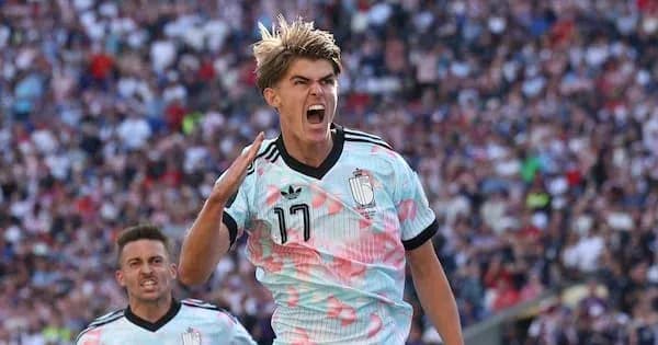 Jugador celebrando gol con camiseta azul y rosa Jugador celebrando gol con camiseta azul y rosa